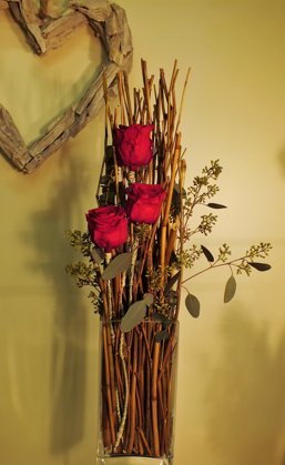 Kompozicija stiklo vazoje su stabilizuotomis rožėmis